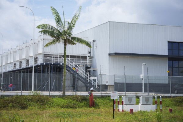 Construction workers stand outside a Data center in construction in Sedenak Tech Park in Johor state of Malaysia, Friday, Sept. 27, 2024. (AP Photo/Vincent Thian)