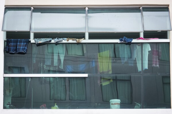 Construction workers hang their laundry at an abandoned shop next to a data center under construction in Johor Bahru town at Johor state, Saturday, Sept. 28, 2024. (AP Photo/Vincent Thian)